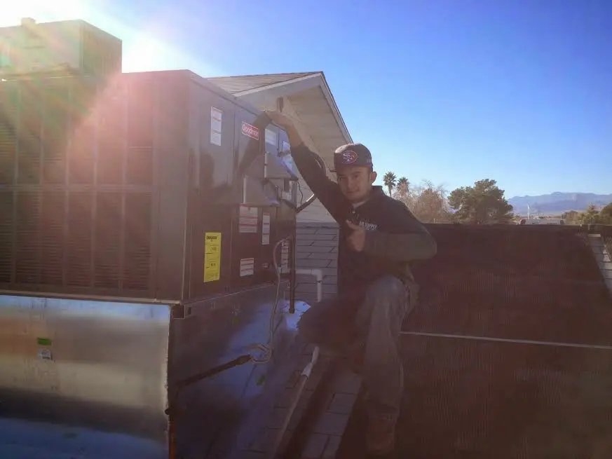 HVAC technician performing AC Tune-Up on a rooftop unit in Hayesville